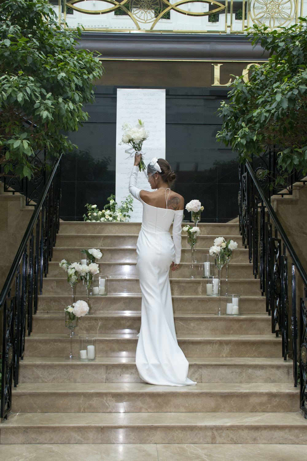 a woman in a white dress walking down a set of stairs