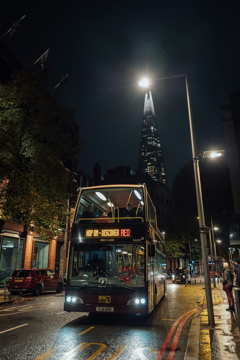 um ônibus de dois andares em uma rua da cidade à noite