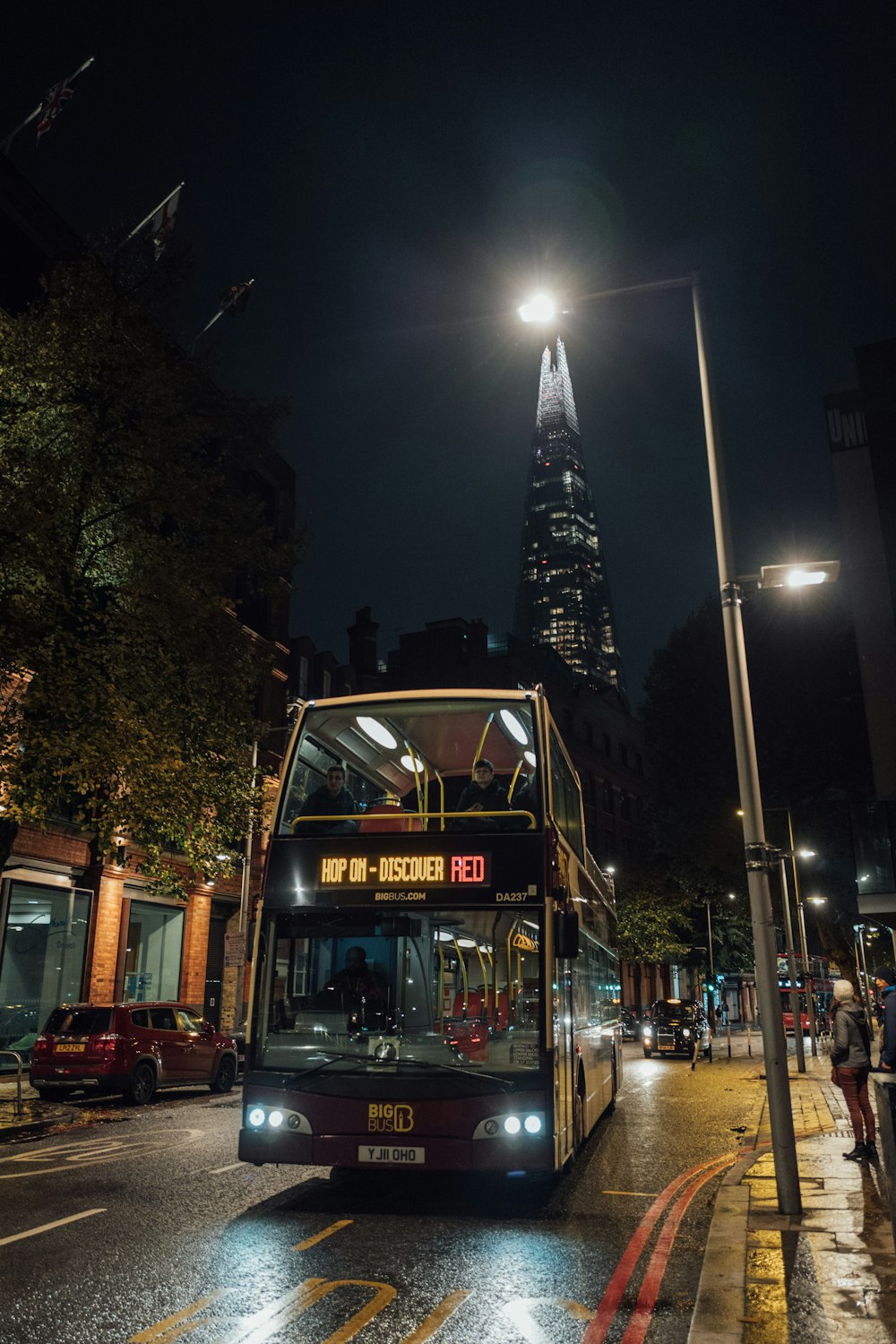 a double decker bus on a city street at night