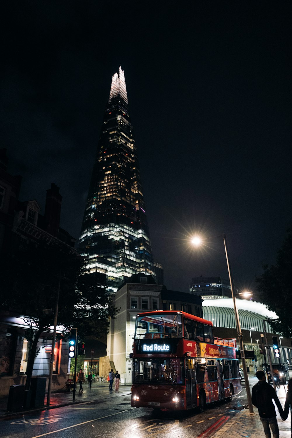 a double decker bus driving past a tall building