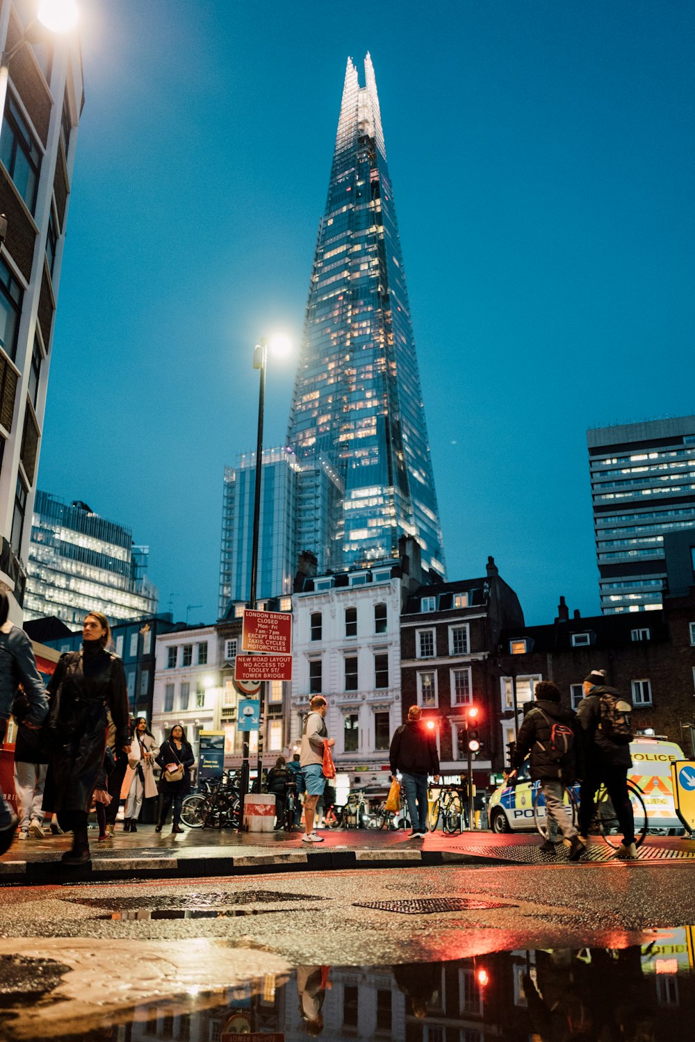 a group of people crossing a street in front of a tall building