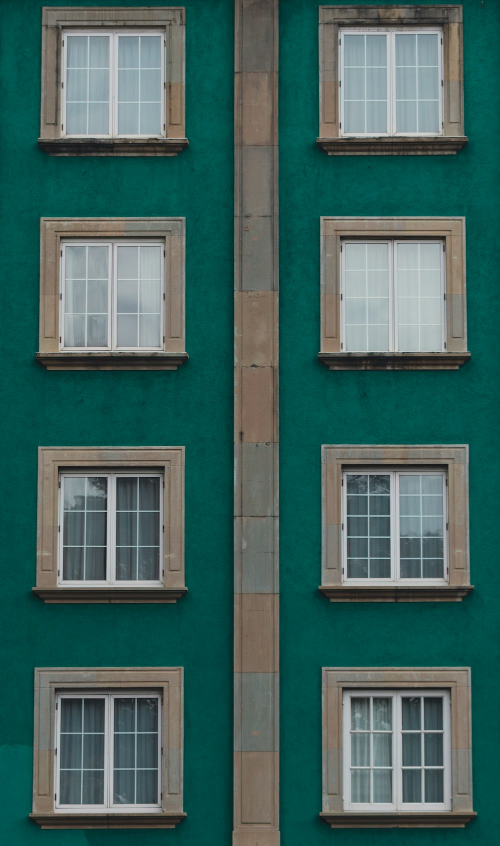 Ein grünes Gebäude mit mehreren Fenstern und einer Uhr