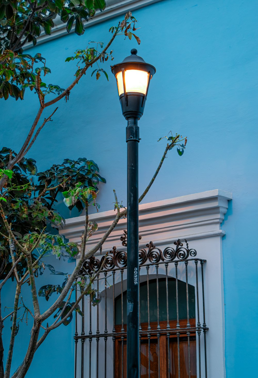 a street light on a pole in front of a blue building