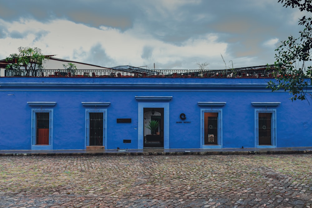 ein blaues Gebäude mit roten Türen und Fenstern