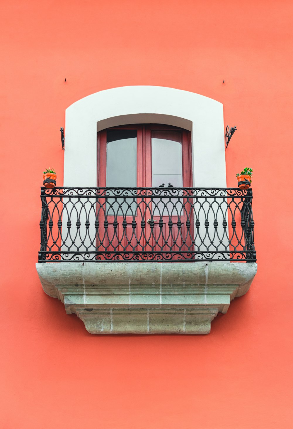 ein rot-weißes Gebäude mit Balkon und roter Tür