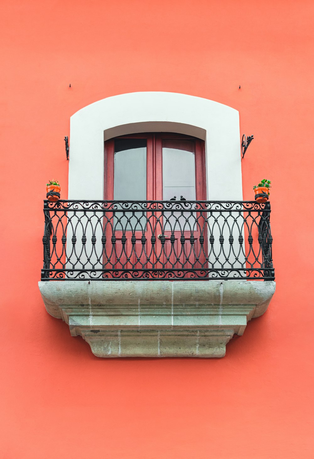 a red and white building with a balcony and a red door