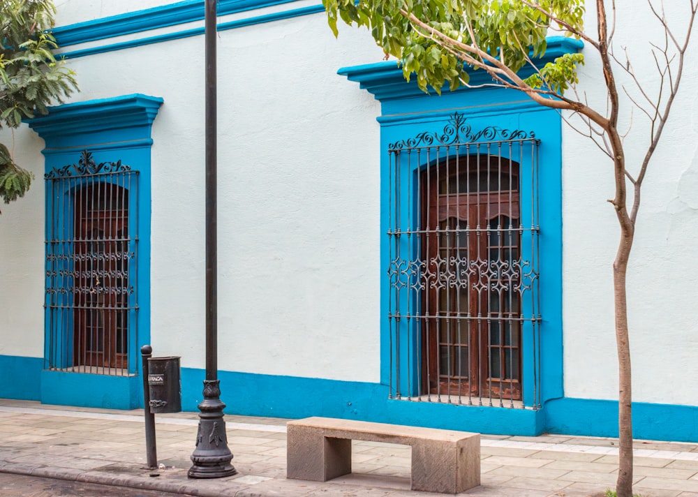 a blue and white building with a bench in front of it