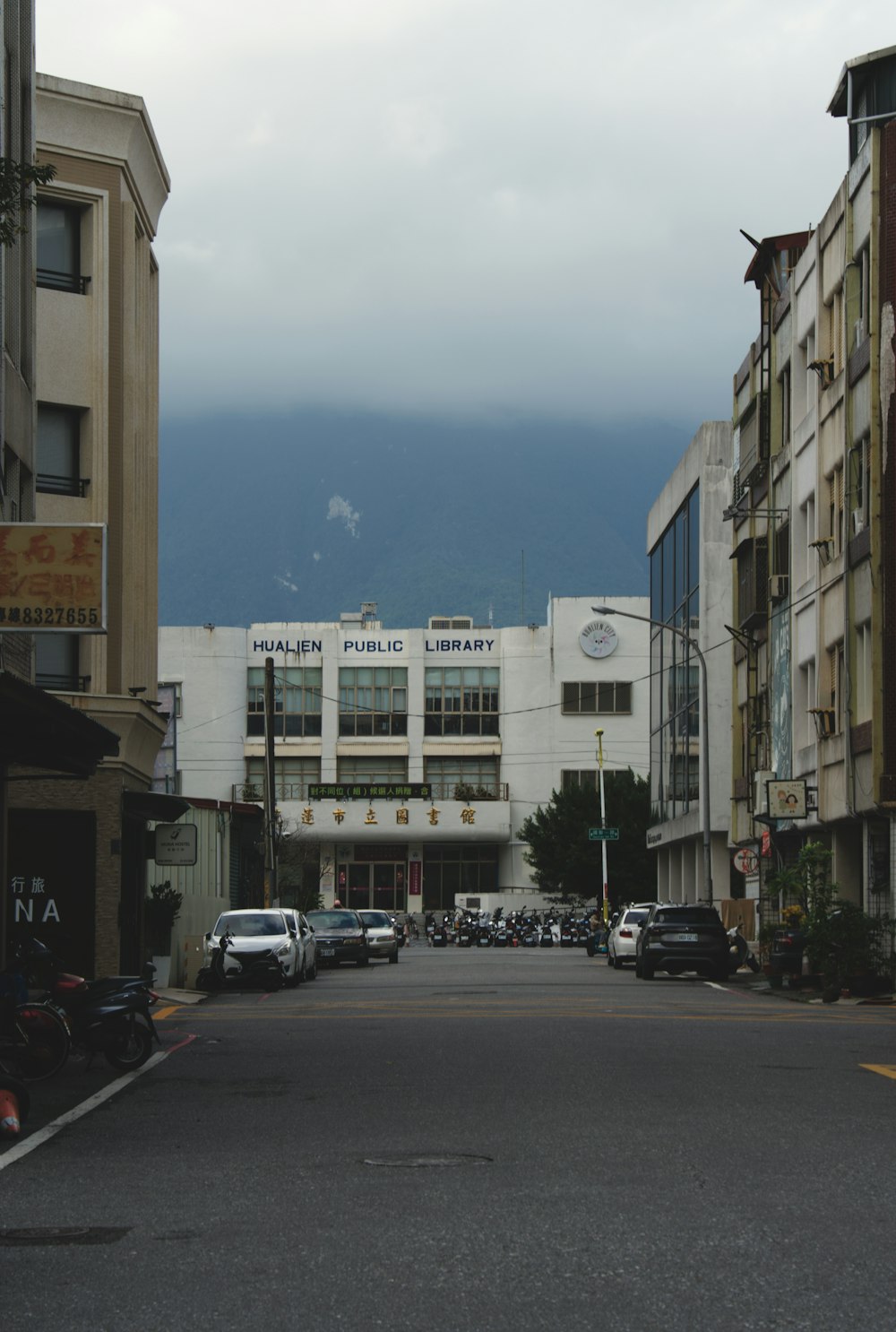 a city street lined with tall buildings under a cloudy sky