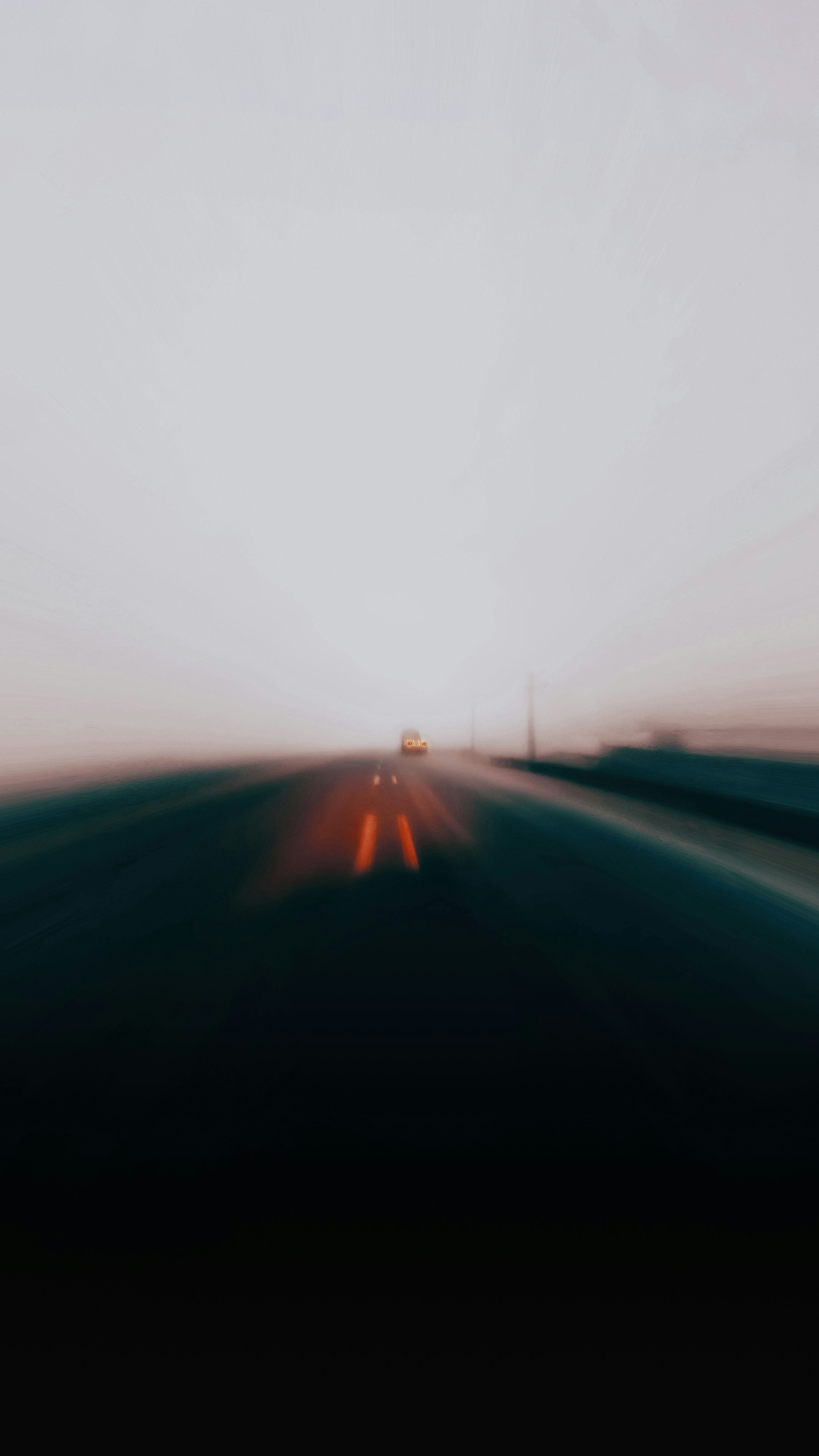 uma foto desfocada de uma rodovia com um carro nela