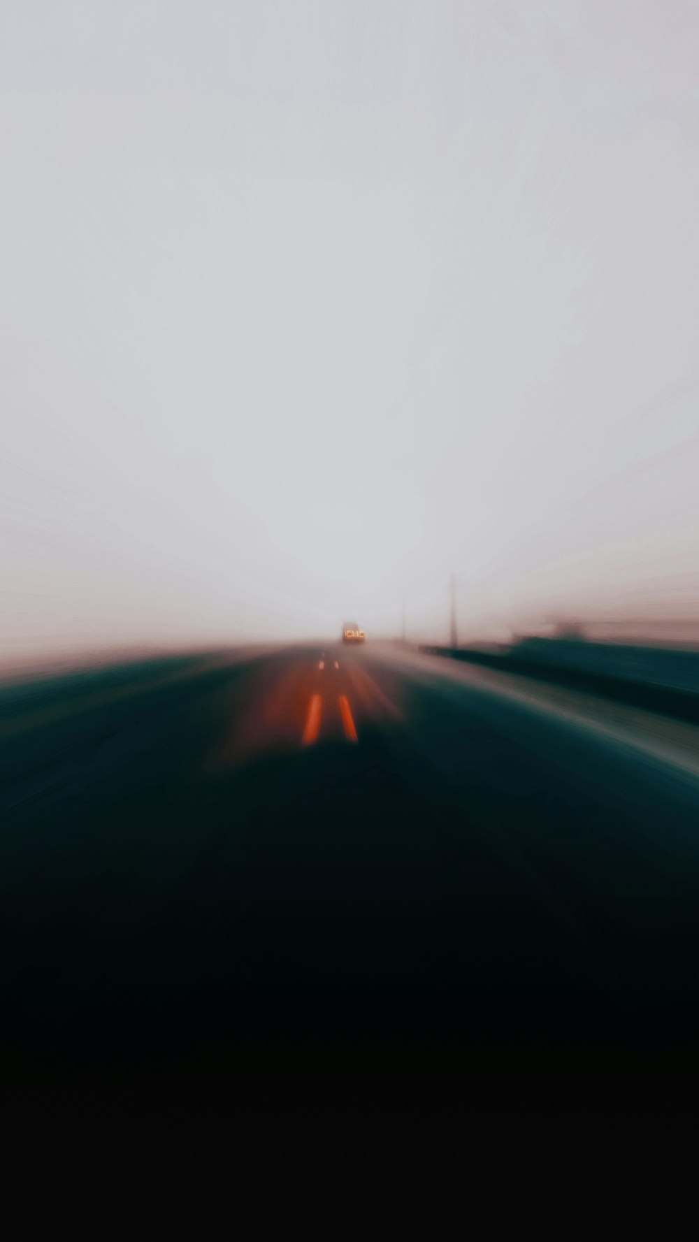 a blurry photo of a highway with a car on it