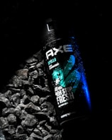 a close up of a bottle of water on a bed of rocks