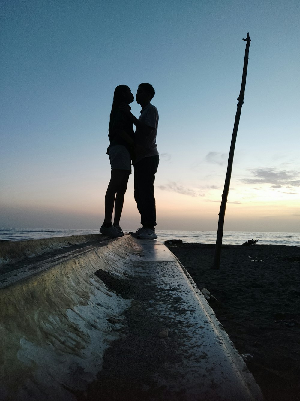 a couple of people standing on top of a pier