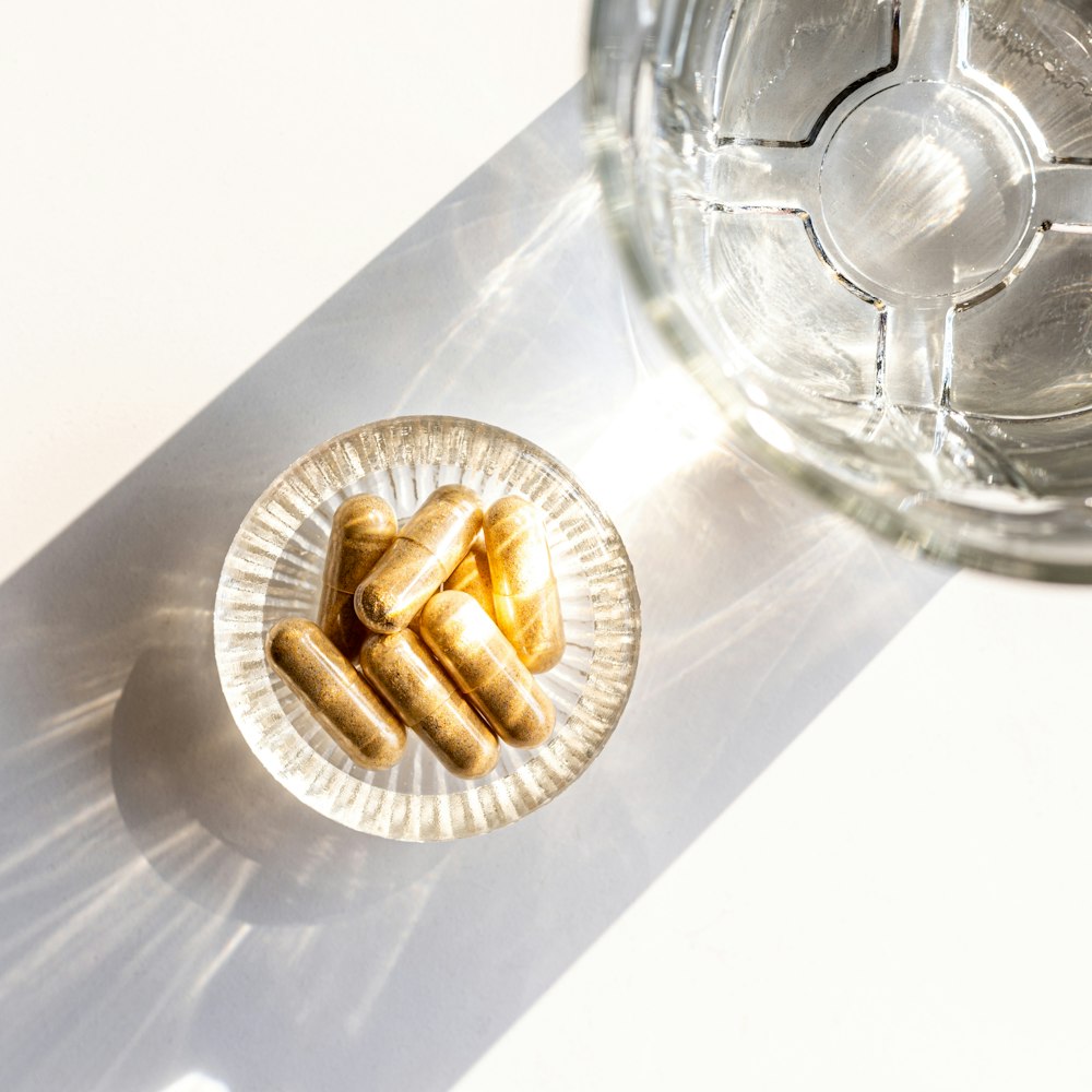 a plate of pills next to a glass of water