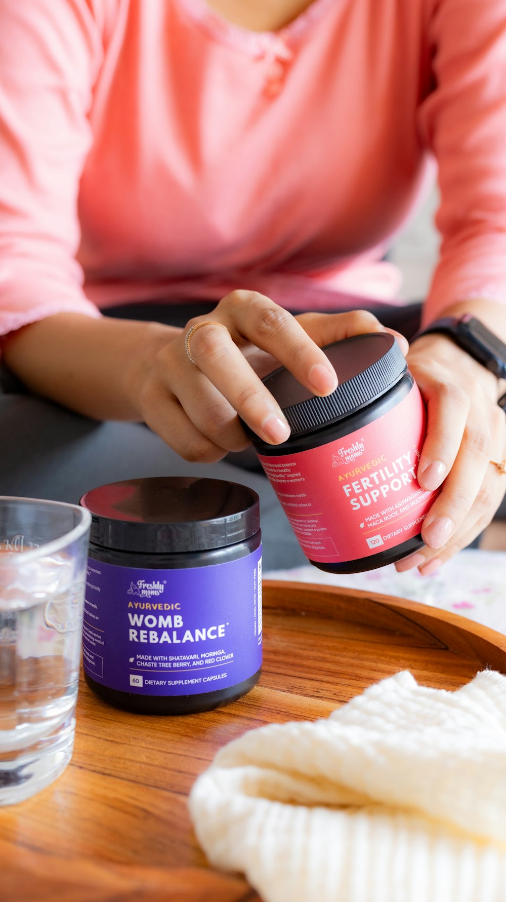 a woman is holding a container of hair products