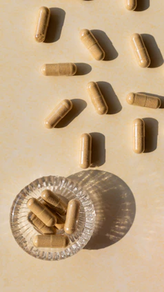 Bright capsules spilling from a wooden bowl on a rustic table
