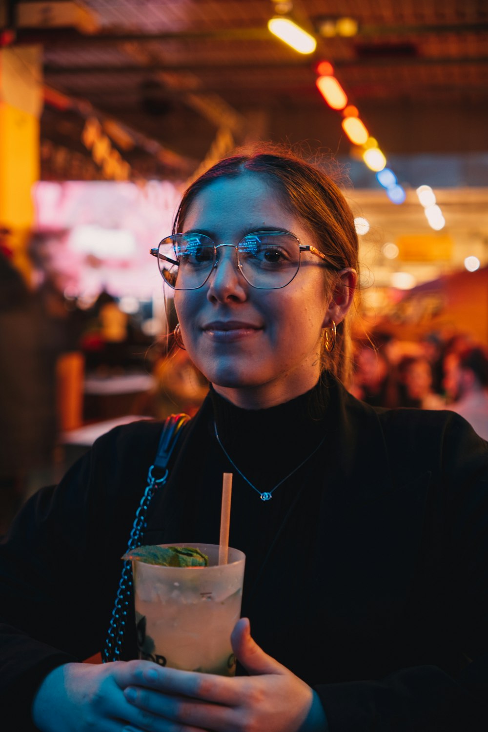 a woman with glasses holding a drink in her hand