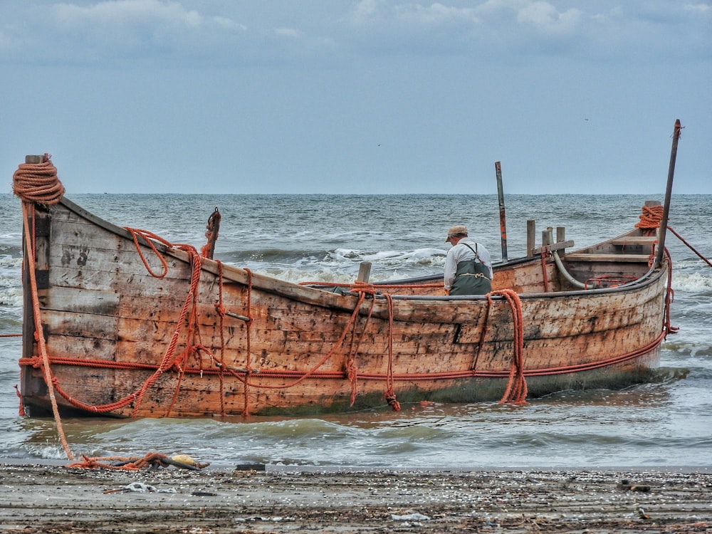 a rusted boat sitting on top of a sandy beach