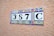 A decorative ceramic tile display with a number '387C' set against a textured terracotta-colored wall. Each tile features ornate patterns with blue, yellow, and red colors.