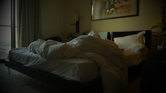 an unmade bed in a dimly lit room
