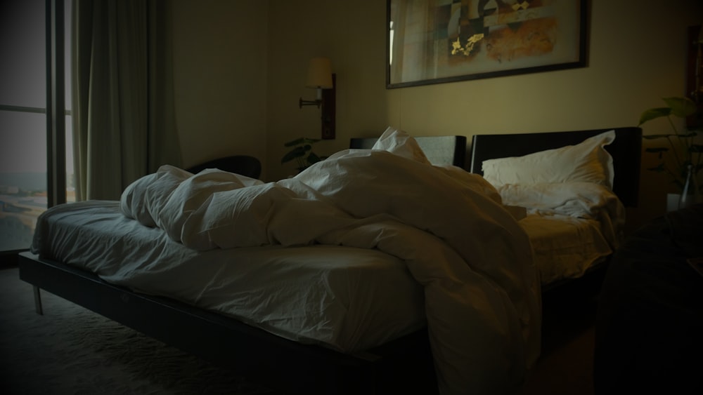 an unmade bed in a dimly lit room