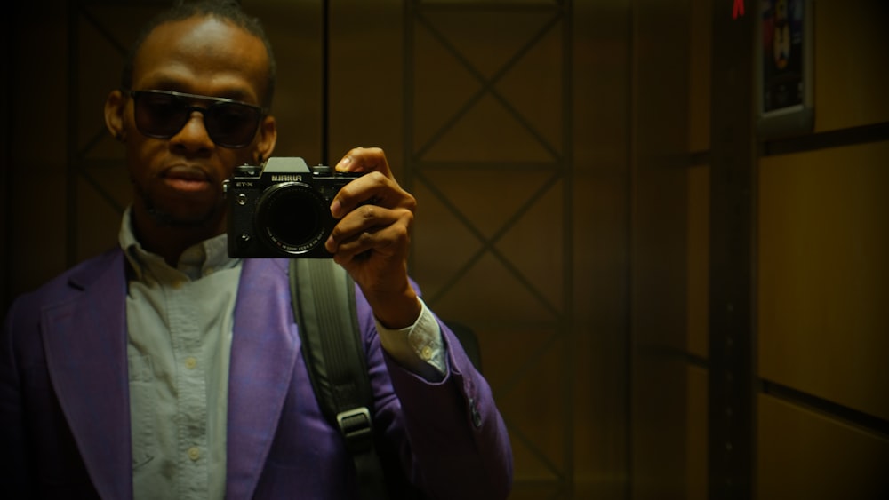 a man in a purple suit taking a picture with a camera