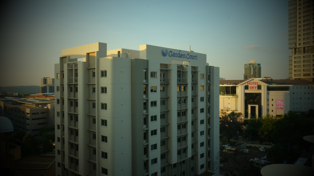 a tall white building sitting next to a tall building