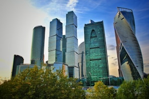 Modern skyline of New Delhi featuring glass buildings and green spaces.