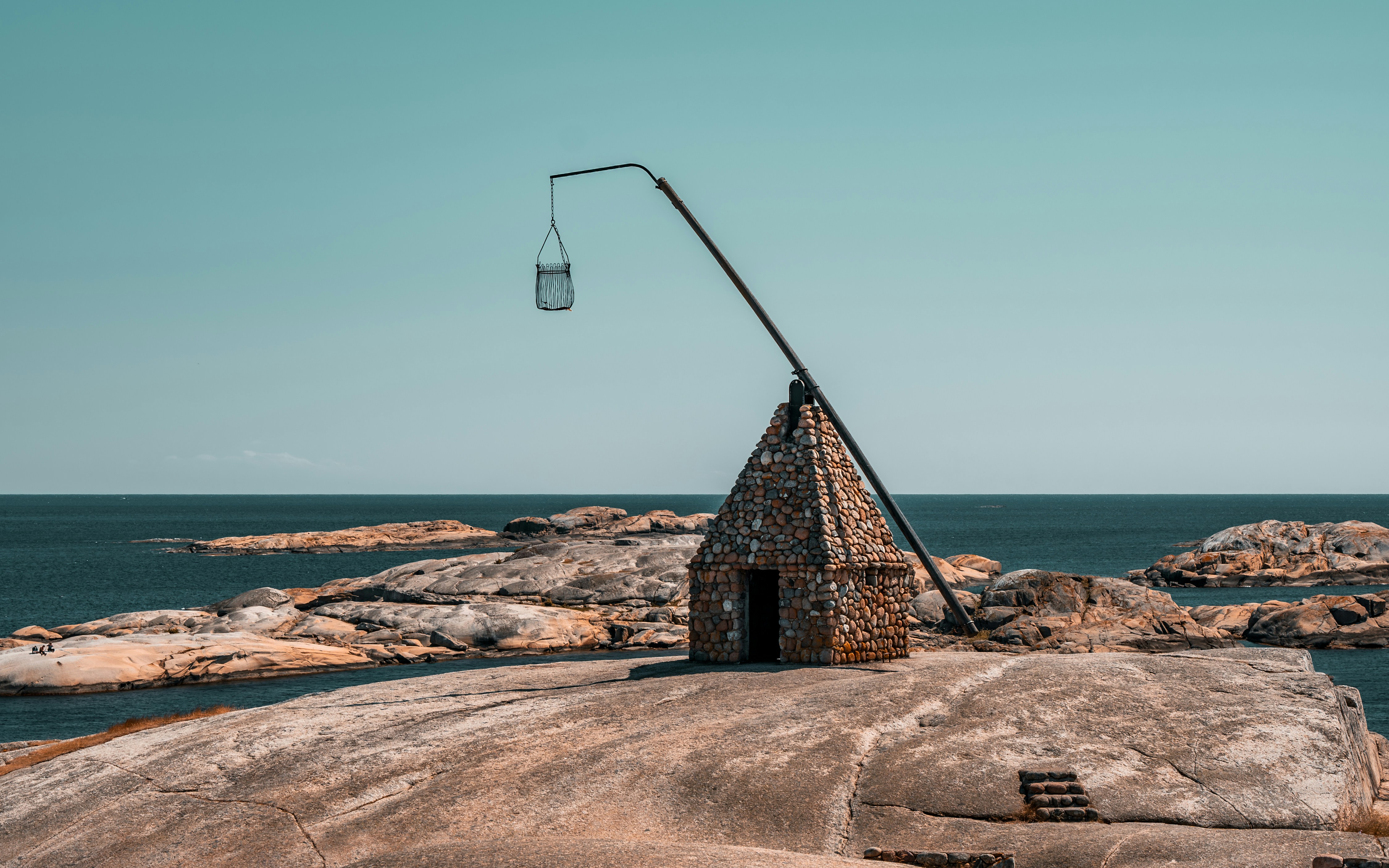 a stone structure sitting on top of a rock next to the ocean