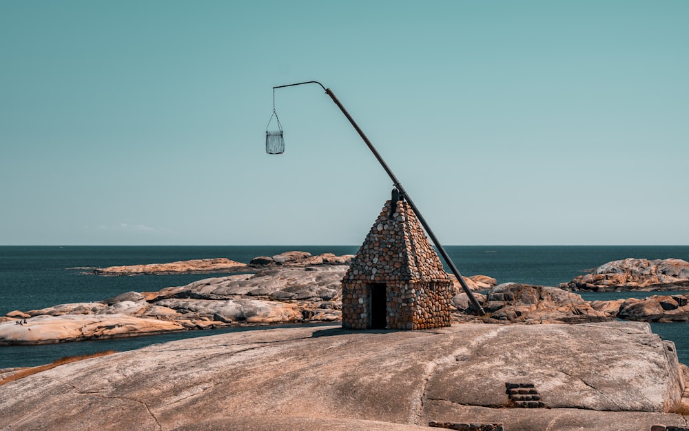 a stone structure sitting on top of a rock next to the ocean