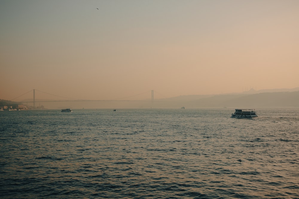 a large body of water with a bridge in the background