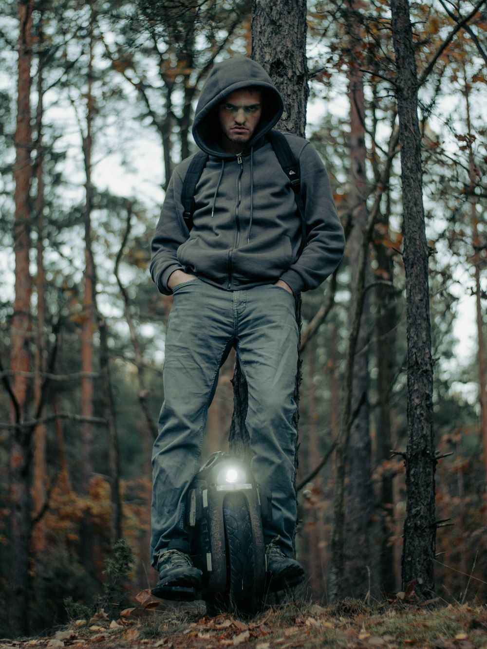 a man standing on top of a tire in the woods