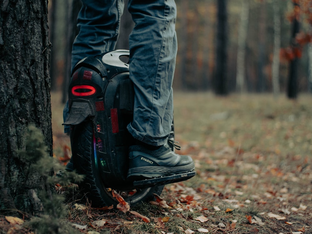 a person standing on top of a skateboard next to a tree