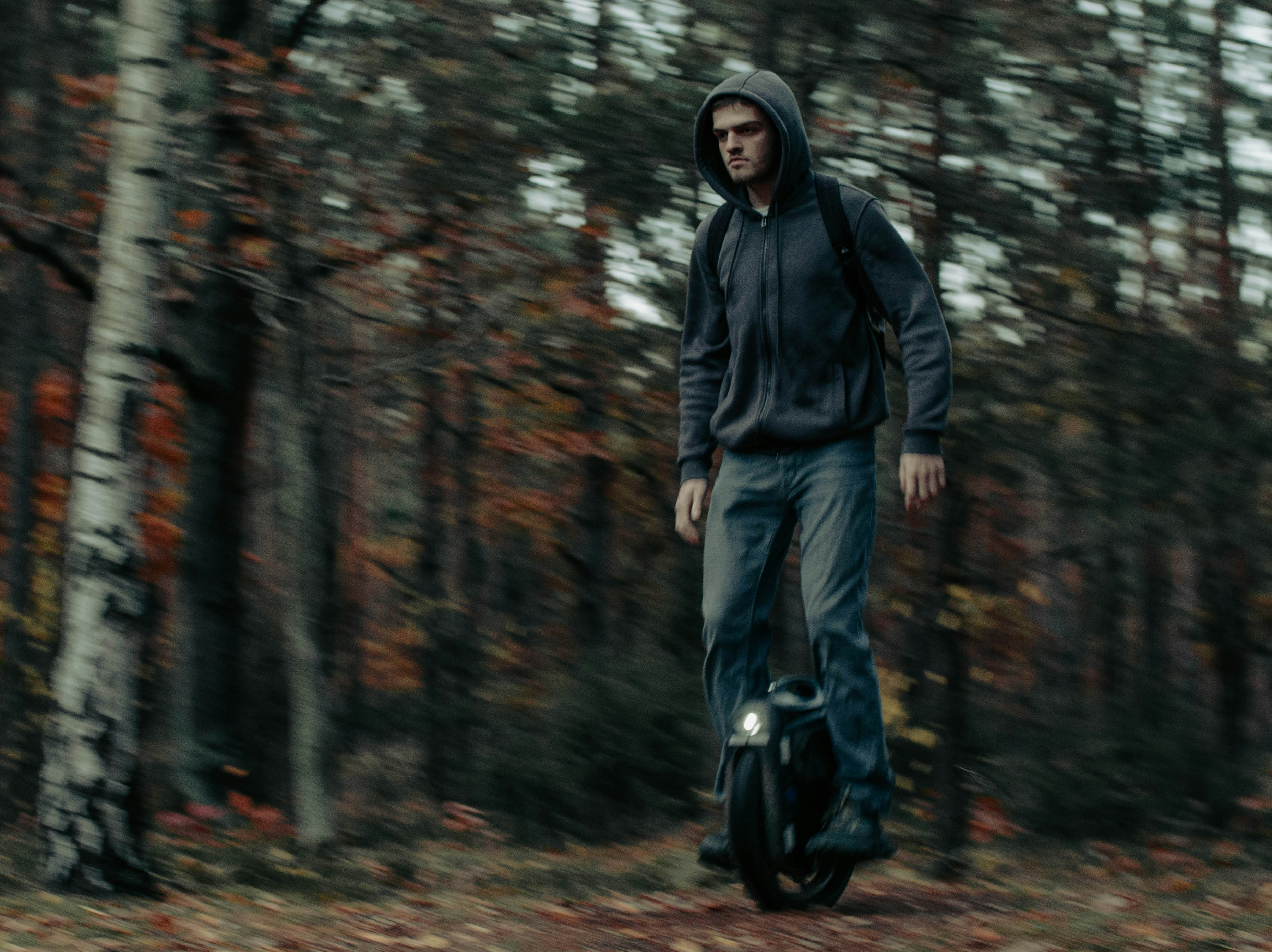 Ein Mann in einem Kapuzenpullover fährt ein Skateboard