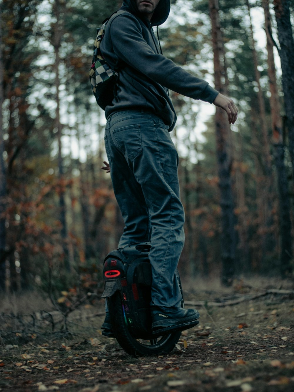 a man riding a skateboard through a forest