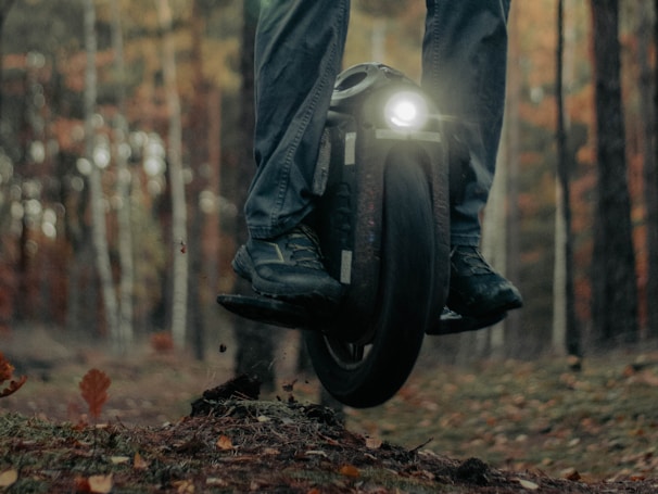 A modern unicycle being ridden in a park.