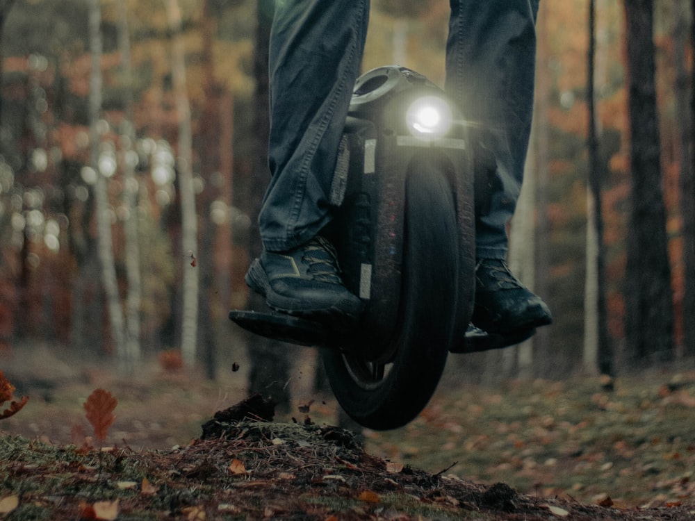a person standing on a bike in the woods