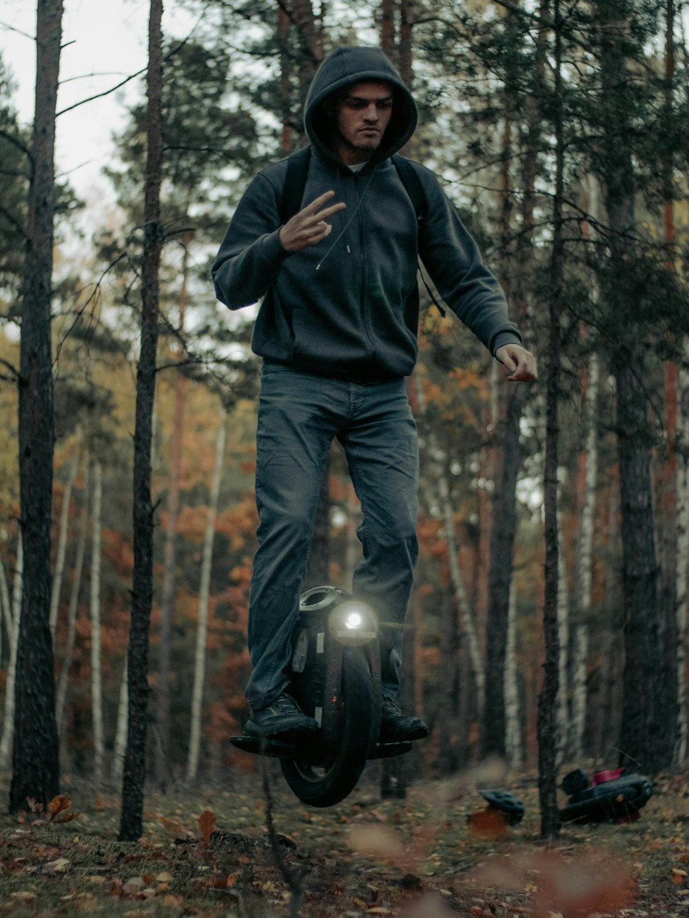 a man riding on the back of a motorcycle through a forest