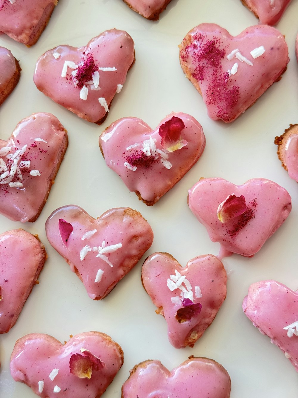 heart shaped pastries with pink icing and white sprinkles