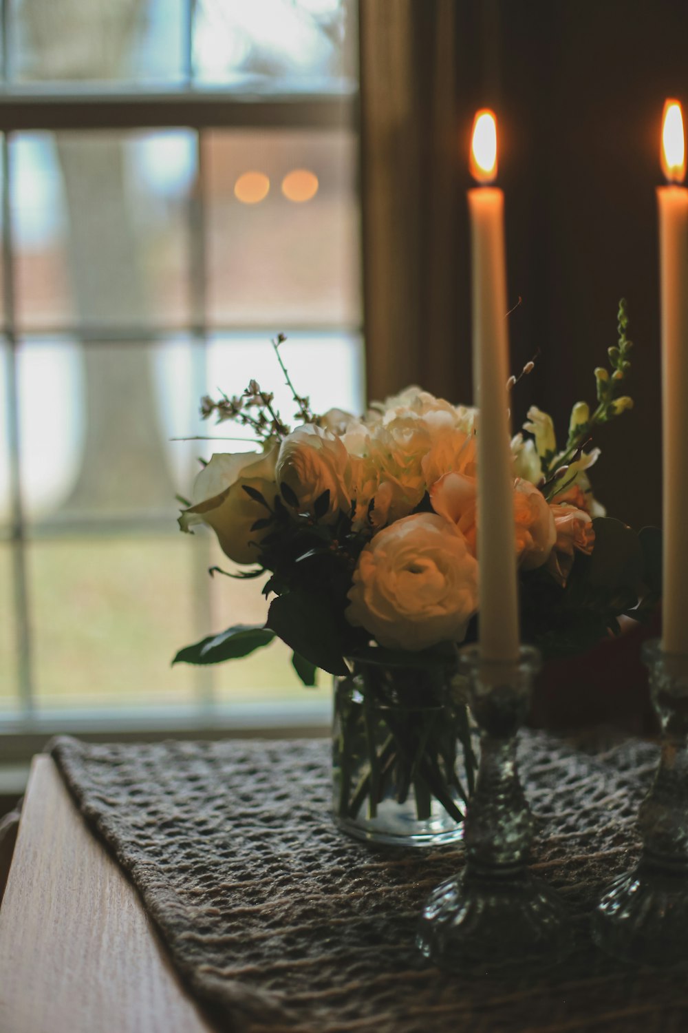 a table topped with two vases filled with flowers