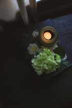 A peaceful memorial candle glowing softly beside a photo album.