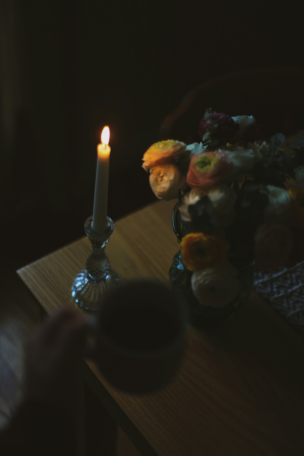 une bougie et un vase de fleurs sur une table