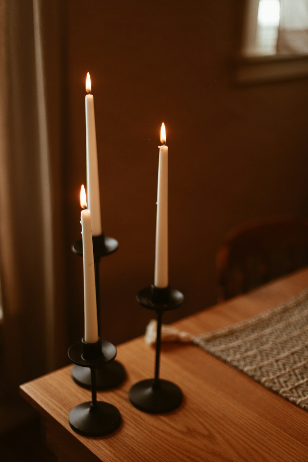 a couple of candles sitting on top of a wooden table