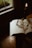 A warm, softly lit scene of an open book resting on a wooden table with a candle flickering nearby.