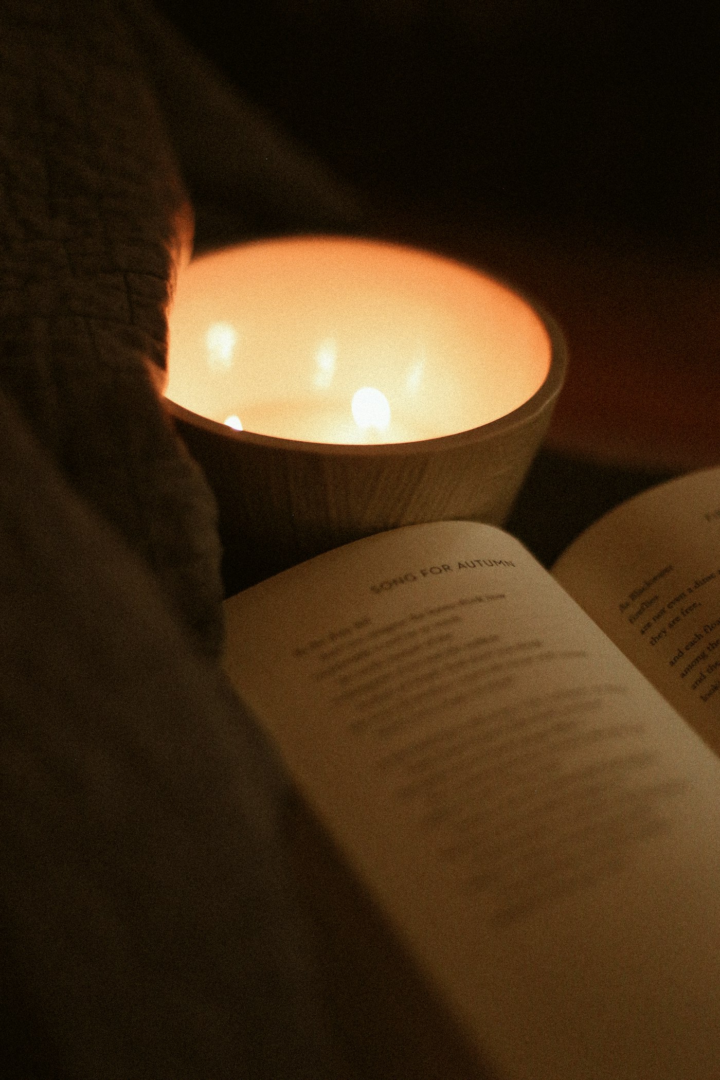 An open book beside a lit candle