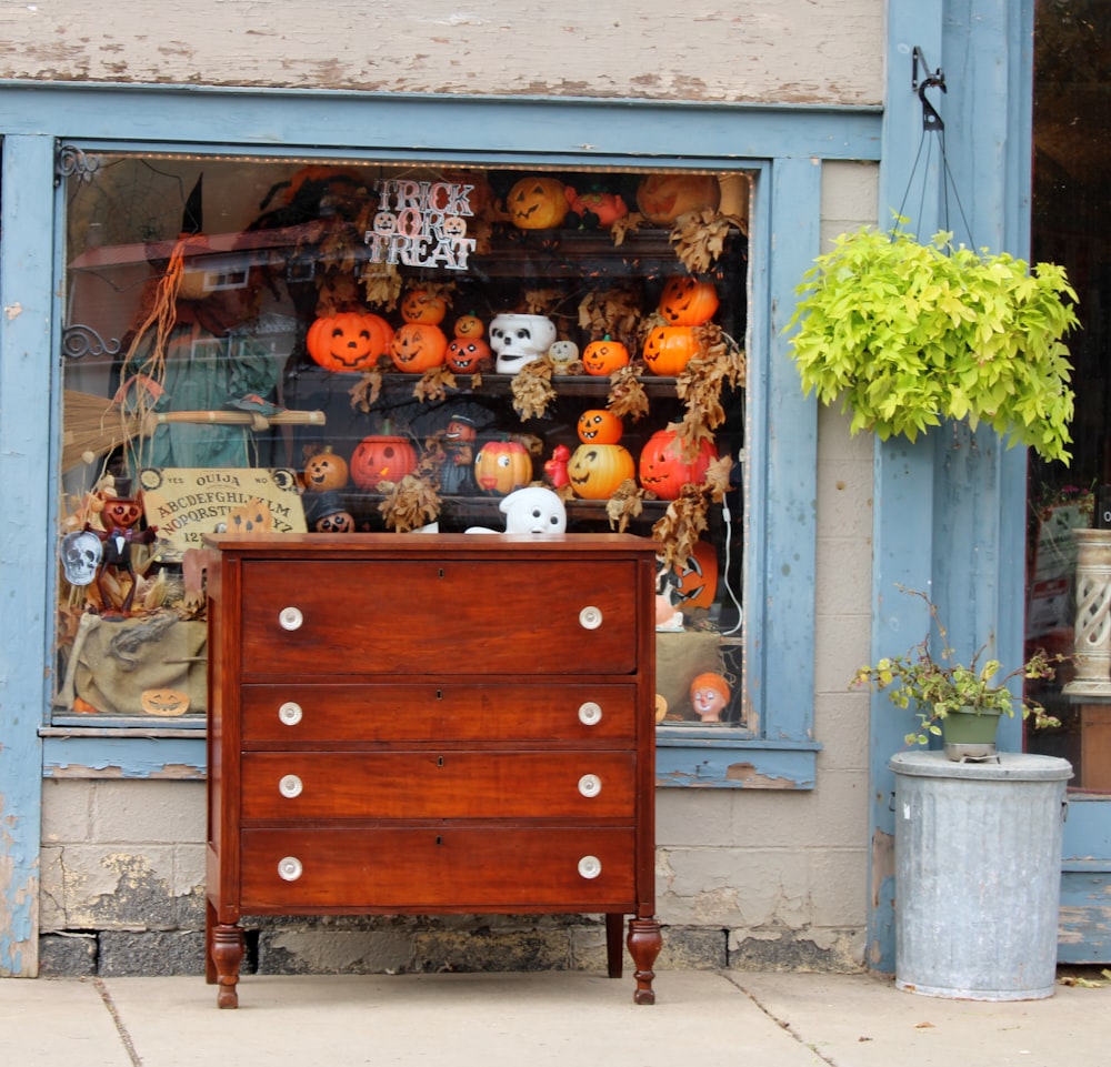a wooden chest of drawers sitting in front of a store
