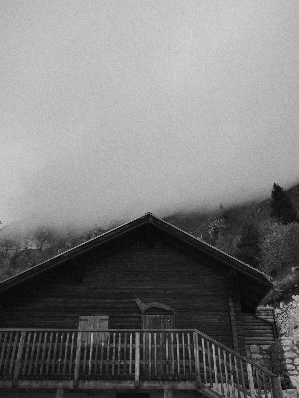 a black and white photo of a wooden cabin