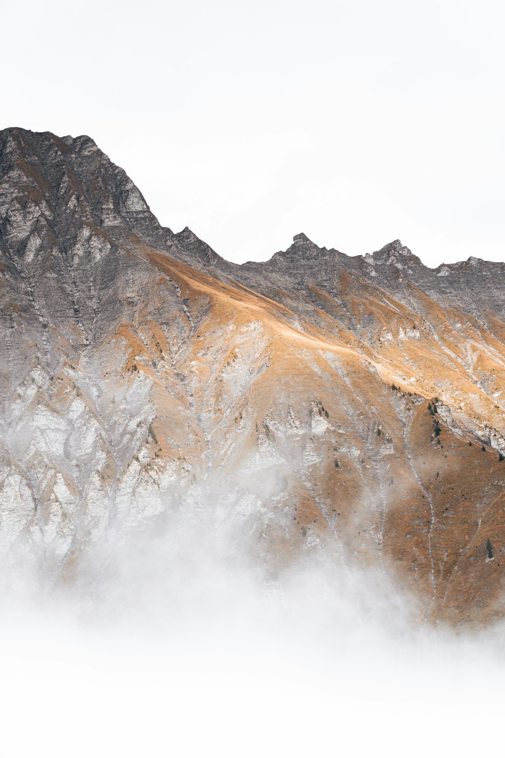 a mountain range covered in snow and clouds