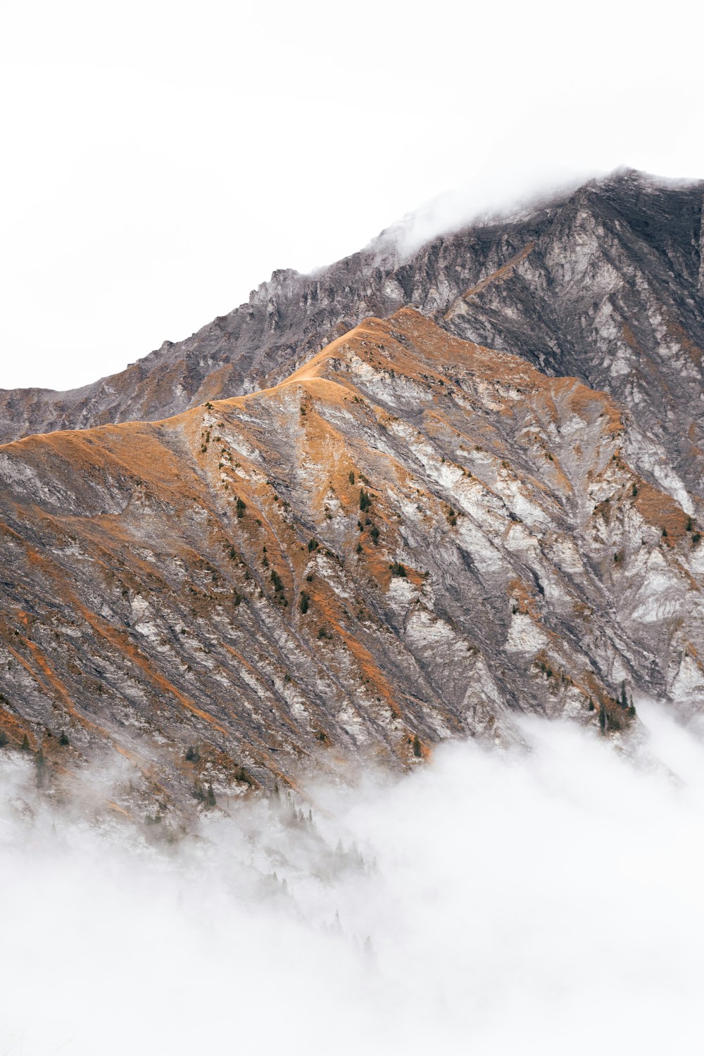 una montaña cubierta de nieve y nubes bajo un cielo nublado