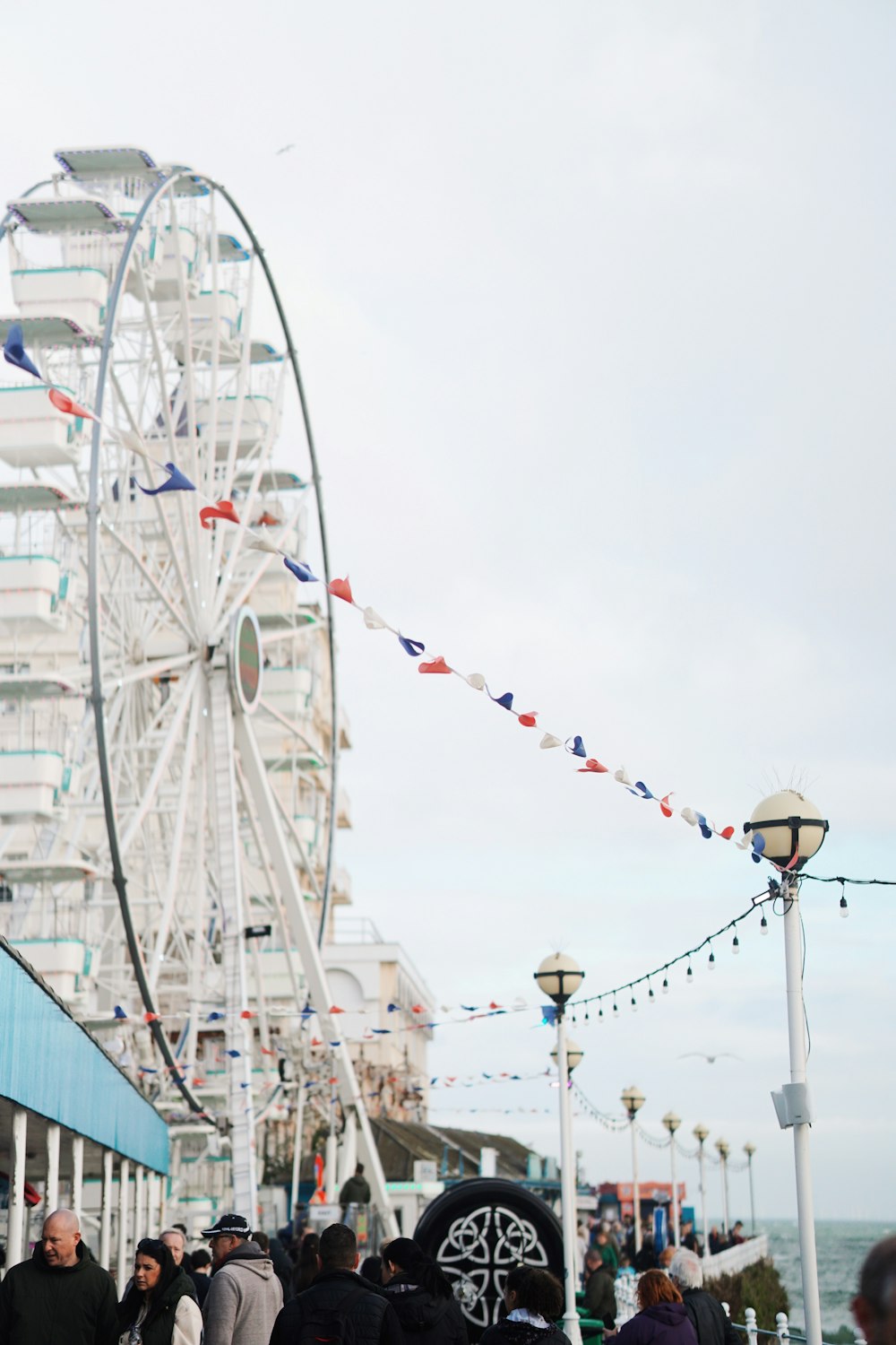 a crowd of people standing around a ferris wheel