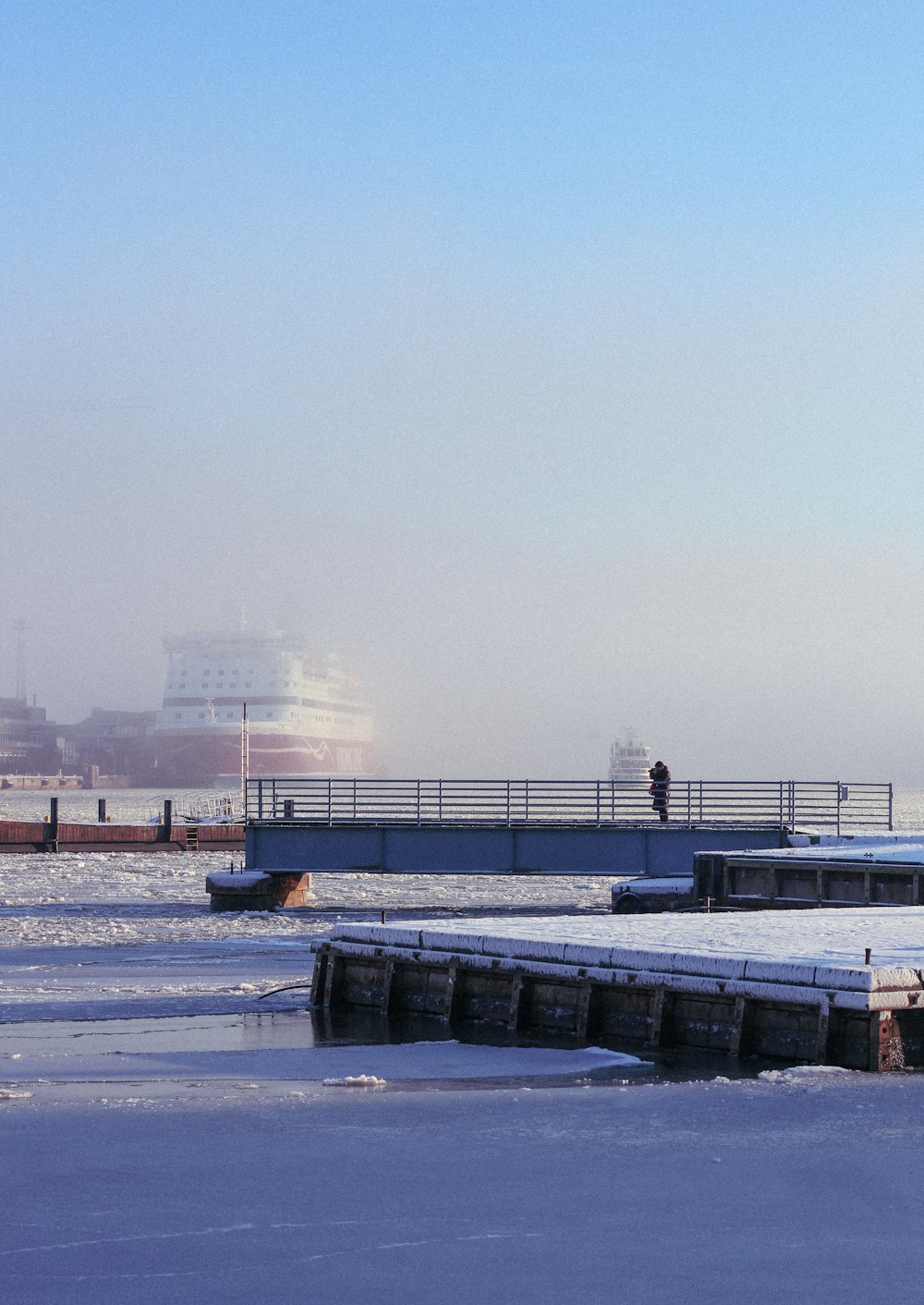 a couple of people walking across a snow covered field